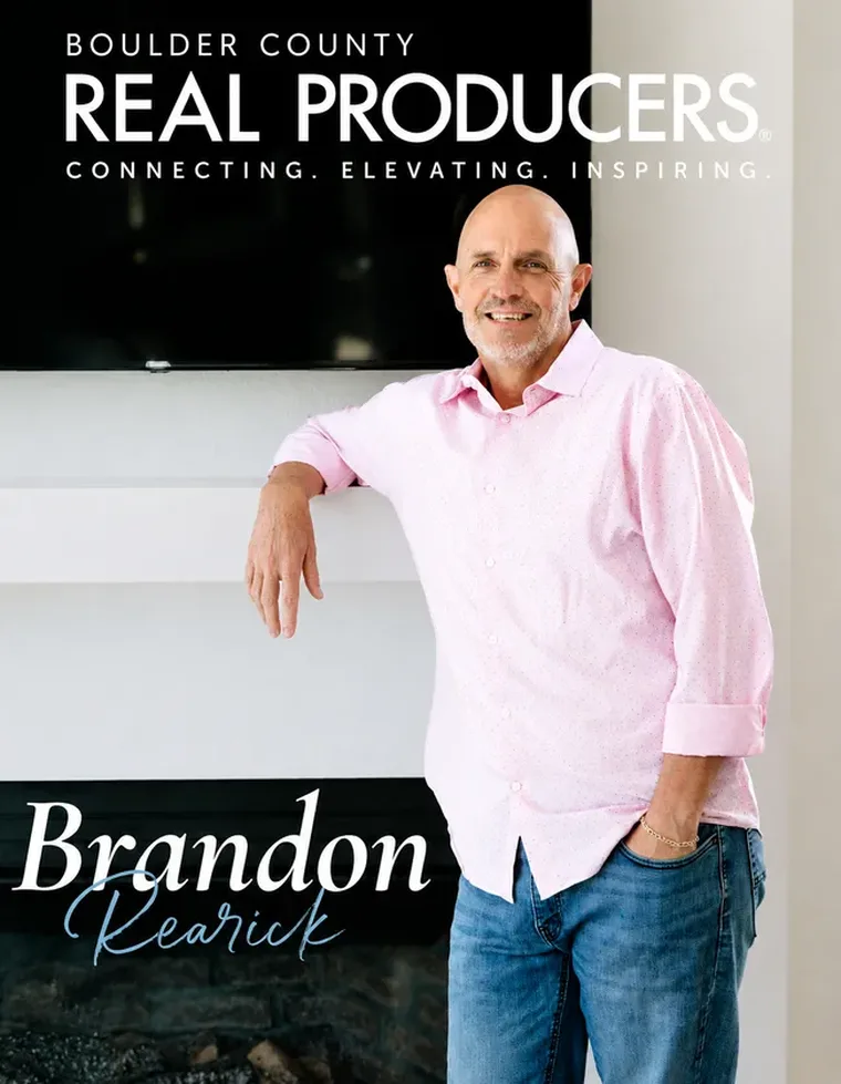 Boulder County Real Producers magazine cover featuring Brandon Rearick leaning against a fireplace