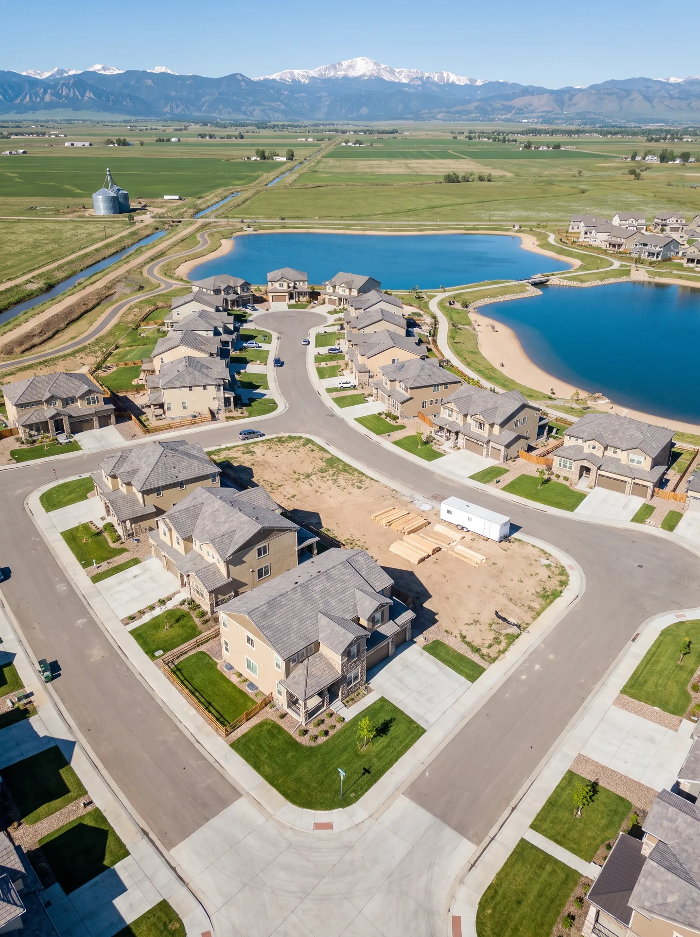 Aerial view of new lakeside homes at Barefoot Lakes in Firestone, Colorado, surrounded by Weld County farmland